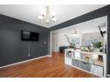 Cozy dining room featuring wood floors, dark accent wall, shelving, and a chandelier at 832 Summit Park Trl, Mcdonough, GA 30253