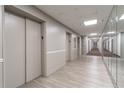 Hallway with light colored wood flooring, elevator doors and a wall of mirrors that go the length of the hall at 215 Piedmont Ne Ave # 204, Atlanta, GA 30308