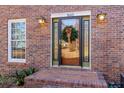 Close-up of the front door with decorative wreath and sidelights, brick facade, and house number at 1645 Dunwoody Sq, Dunwoody, GA 30338