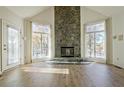 Bright living room with a striking floor-to-ceiling stone fireplace and beautiful hardwood floors at 205 Pine Knott Rd, Fayetteville, GA 30214