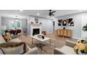 Open-concept living room featuring a stone fireplace, modern decor, and hardwood flooring at 185 Bob White Dr, Stockbridge, GA 30281