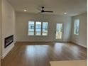 Open living room with hardwood floors, a modern fireplace, and access to an outdoor deck at 1932 Appian Aly, Kennesaw, GA 30144