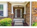 Inviting front entrance featuring a stone facade, covered porch, and classic brown door at 3455 Dalwood Dr, Suwanee, GA 30024