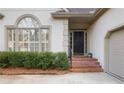 Stately front entrance with brick steps, black door, and manicured shrubbery at 3923 Ashford Ne Trl, Brookhaven, GA 30319