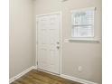 Bright entryway with a white door, window with blinds, and hardwood floors at 5063 Lower Elm St, Atlanta, GA 30349