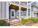 Inviting front porch with brick accents, white railing, and comfortable seating; perfect for relaxing at 2304 Isla Run, Woodstock, GA 30188