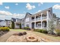 Landscaped front yard with a cozy stone fire pit and a charming two-story home with a double-decker porch at 2304 Isla Run, Woodstock, GA 30188