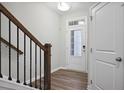 Bright entryway with wooden floors, features a staircase with black iron railings and a white front door at 100 Duval Dr, Alpharetta, GA 30009