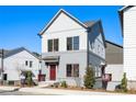 New two-story home with light gray siding, red entry door and small porch on a sunny day at 3326 Springhaven Ave, Hapeville, GA 30354