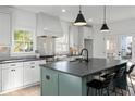 Bright kitchen with a large center island, pendant lighting, stainless steel appliances, and white cabinets at 3326 Springhaven Ave, Hapeville, GA 30354