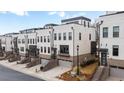 White and brick modern townhome community street view showing garage, stairs, and landscaping at 4374 Benfield Se Way # 1801Lo, Smyrna, GA 30080