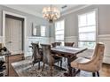 Formal dining room with wainscoting, decorative chandelier, and seating for six at 1180 John Collier Rd, Atlanta, GA 30318