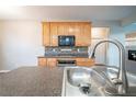 Kitchen with stainless steel appliances, wood cabinets, stylish backsplash, and granite countertops at 2397 Shady Maple Trl, Loganville, GA 30052