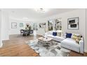 Bright and airy living room featuring a modern sofa, stylish rug, and hardwood floors at 438 Ansley St, Decatur, GA 30030