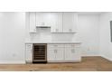 Modern wet bar with white cabinets, wine cooler, and light countertops at 438 Ansley St, Decatur, GA 30030