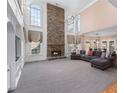 Open-concept living room with soaring ceilings, stone fireplace, and large windows with natural light at 2560 Millwater Xing, Dacula, GA 30019