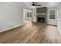 Bright living room with a brick fireplace, ceiling fan, and wood floors at 6390 E Stubbs Rd, Atlanta, GA 30349