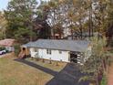 Renovated home featuring a black asphalt driveway, white brick exterior, and dark trim at 1970 Capri Dr, Decatur, GA 30032