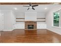 Spacious living room features hardwood floors, brick fireplace, ceiling fan, and built-in shelving at 222 Trecastle Sq # 21, Canton, GA 30114