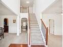 Bright entryway featuring a staircase with wood and iron railings and views into the dining room at 248 Allegrini Dr, Atlanta, GA 30349