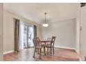Bright dining area with laminate wood floors, a pendant light fixture, and sliding door to outside at 654 Powers Ferry North Se, Marietta, GA 30067