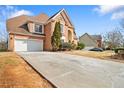 Spacious driveway leading to a brick home with a two-car garage and well-kept landscaping at 2905 Ridge Oak Dr, Suwanee, GA 30024