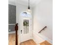 A foyer with a hardwood floor, white front door, and a clear glass pendant light at 2447 Gatebury Cir, Chamblee, GA 30341