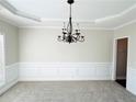 Elegant dining room with a decorative chandelier, carpeted floor, and wainscoting at 4425 Idlewood Dr, Cumming, GA 30040