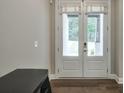 Bright entryway featuring wood floors, white trim, and a set of double doors leading to the backyard at 58 Cherry St, Lawrenceville, GA 30046