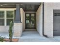 The covered front porch boasts brick columns and a gray front door, leading to a charming entrance at 58 Cherry St, Lawrenceville, GA 30046
