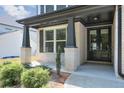 Covered front porch entrance featuring brick columns, a gray front door and manicured bushes at 58 Cherry St, Lawrenceville, GA 30046