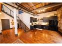 Open living room with staircase and modern kitchen featuring dark cabinets and wood flooring at 342 Marietta Nw St # 8, Atlanta, GA 30313