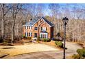 Beautiful brick home nestled among trees, with a circular driveway and professionally landscaped front yard at 3595 Mason Ridge Dr, Winston, GA 30187