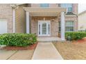 A welcoming front porch of a brick home with a decorative door and manicured bushes at 610 Maltese Dr, Atlanta, GA 30349