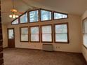 Bright living room featuring a wall of windows, a ceiling fan and neutral carpeting at 1046 Sans Souci Way, Clarkston, GA 30021