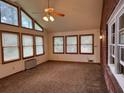 Bright living room featuring a wall of windows, a ceiling fan and neutral carpeting at 1046 Sans Souci Way, Clarkston, GA 30021