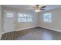 Bright living room boasts wood-look flooring, two windows, a white entry door, and a ceiling fan at 645 Plainville Sw Dr, Atlanta, GA 30331