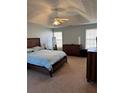 Well-lit bedroom with a ceiling fan, light blue walls, and carpeted flooring at 1176 Whatley Mill Ln, Lawrenceville, GA 30045