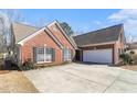 Side view of a brick home featuring an attached garage and well-maintained landscaping at 1176 Whatley Mill Ln, Lawrenceville, GA 30045