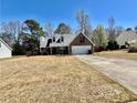 Well-maintained home with a brick facade, dormer windows, two-car garage, and a spacious lawn at 310 Creekside Trl, Covington, GA 30016