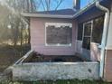 Exterior of home showing boarded-up windows and overgrown yard needing repair at 750 Alta Pl, Atlanta, GA 30318