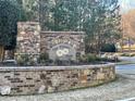 Community entrance sign shows brick and stone details, landscaping, and street sign at 222 Blossom Trl, Acworth, GA 30101