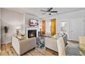 Cozy living room boasts a fireplace, hardwood floors, and natural light from windows dressed with stylish curtains at 6089 Mallory Rdg, Union City, GA 30291