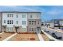 New townhome with a well-manicured lawn and neutral exterior brick and white siding at 2212 Whistler Ne Way, Lawrenceville, GA 30043
