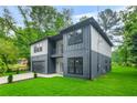 Attractive home with modern architecture, a private balcony, an attached garage and verdant lawn at 921 Cone Rd, Forest Park, GA 30297