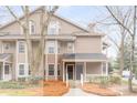 Townhouse with a tan exterior, black door, and a small front porch with white railing at 2116 N Forest Trl, Atlanta, GA 30338