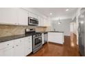 Modern kitchen with stainless steel appliances, granite countertops, and white cabinets at 2116 N Forest Trl, Dunwoody, GA 30338