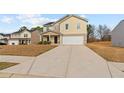 Inviting two-story house with a long driveway leading to an attached two-car garage at 310 Indian Lake Trl, Villa Rica, GA 30180