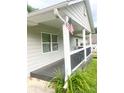 View of covered porch with black wood railing and American flag at 4567 Duncan Dr, Sugar Hill, GA 30518