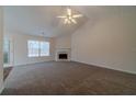 Inviting living room with a cozy fireplace, neutral carpet, and a large window at 946 Village View Cir, Loganville, GA 30052